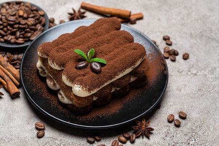 Classic tiramisu dessert on ceramic plate on concrete backgroundの写真素材