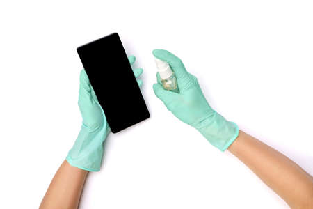 Females hands wiping mobile phone with alcohol sanitizing agent, top view on white backgroundの写真素材