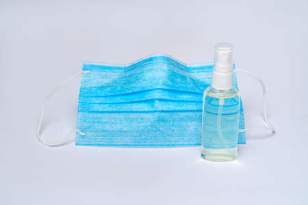 bottle of lotion, sanitizer or liquid soap and protective mask over light grey background.の写真素材