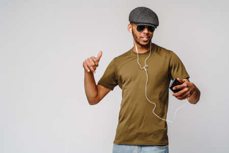 studio shot young african american man listening to music with earphones