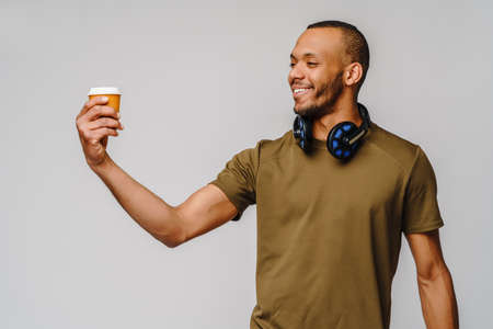 Cheerful african american guy drinking coffee to goの写真素材