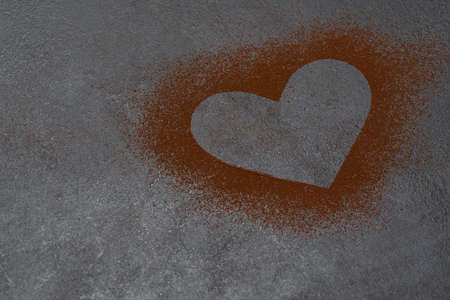 Heart shape of spreading cocoa powder on concrete backgroundの写真素材