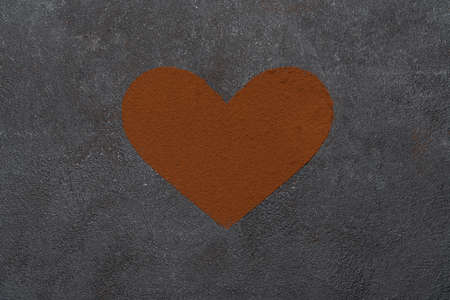 Heart shape of spreading cocoa powder on concrete backgroundの写真素材