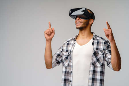 Young African-American young man wearing vr virtual reality headset over light grey backgroundの写真素材