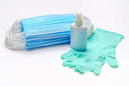 Disposable blue medical face mask, rubber latex gloves and alcohol hand sanitizer antiseptic on...