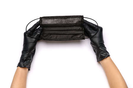 Human hand in protective glove holding face protective masks isolated on white background