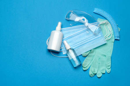 Safety equipment to fight to Coronavirus COVID-19 virus outbreak - Safety mask, hand sanitizer, latex gloves and protective glasses or gogglesの写真素材
