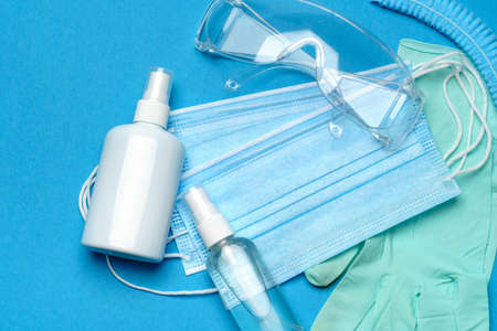 Safety equipment to fight to Coronavirus COVID-19 virus outbreak - Safety mask, hand sanitizer, latex gloves and protective glasses or gogglesの写真素材