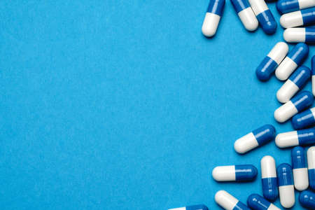 group of pills or capsules on blue background