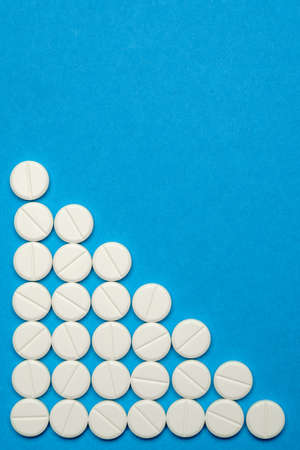 group of round white pills on blue backgroundの写真素材
