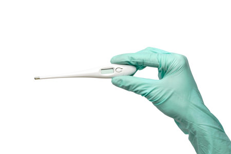 close up hand in a latex glove with thermometer isolated on a white backgroundの写真素材
