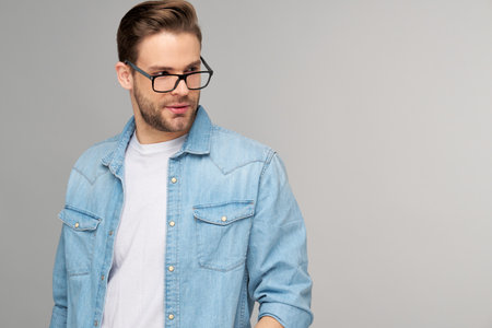 Portrait of young handsome caucasian man in jeans shirt over light backgroundの写真素材