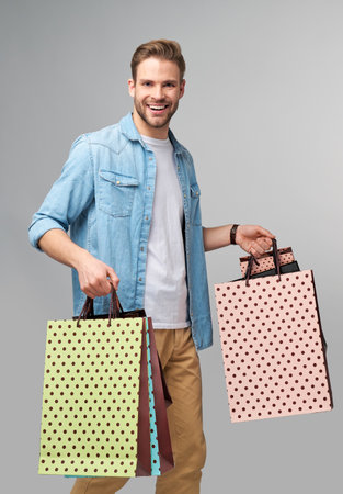 Portrait of a handsome young man with shopping bagsの写真素材