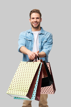 Portrait of a handsome young man with shopping bagsの写真素材