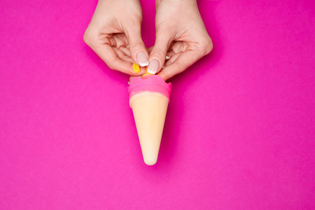 Beautiful Female well-groomed Hands with French manicure over pink backgroundの写真素材