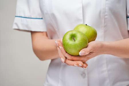 nutritionist doctor healthy lifestyle concept - holding organic fresh green appleの写真素材