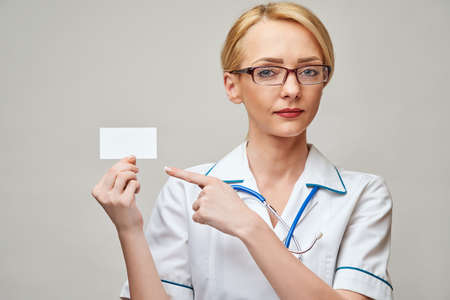 Medical worker doctor or nurse showing blank business card sign with copy space for text or design