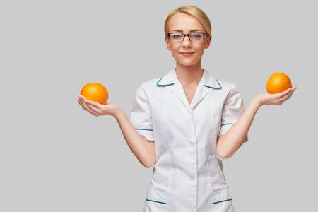 nutritionist doctor healthy lifestyle concept - holding orange fruitの写真素材
