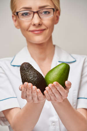 nutritionist doctor healthy lifestyle concept - holding organic avocado fruitの写真素材