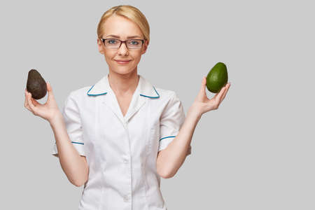 nutritionist doctor healthy lifestyle concept - holding organic avocado fruitの写真素材