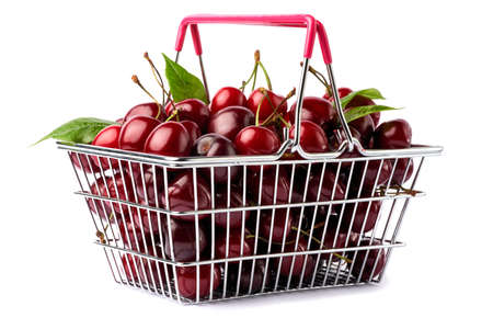 shopping basket full of sweet cherry fruits isolated on white backgroundの写真素材