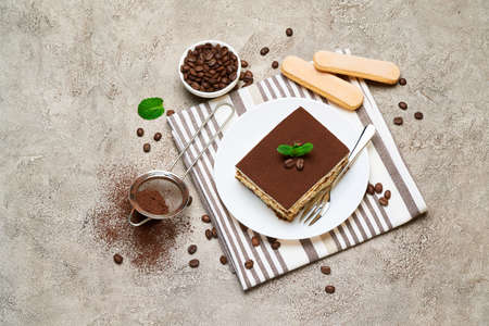 Portion of Traditional Italian Tiramisu dessert and coffee beans on grey concrete backgroundの写真素材