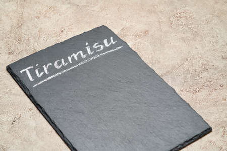 Stone serving menu board with chalk handwritten Tiramisu signの写真素材