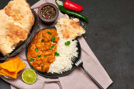 Plate of Traditional Chicken Curry and rice on dark concrete background