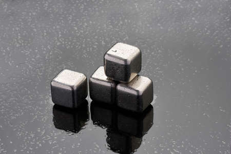 Steel cooling cubes for cocktail drink on glass background
