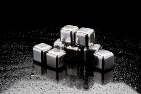 Steel cooling cubes for cocktail drink on glass backgroundの写真素材