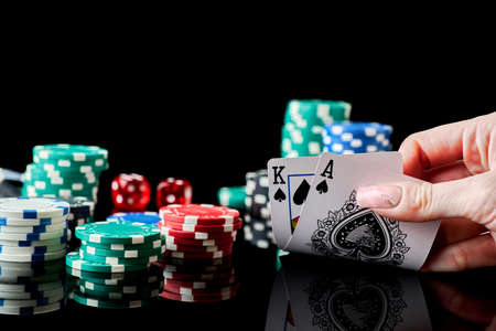 Casino chips, playing cards and dices on dark reflective background