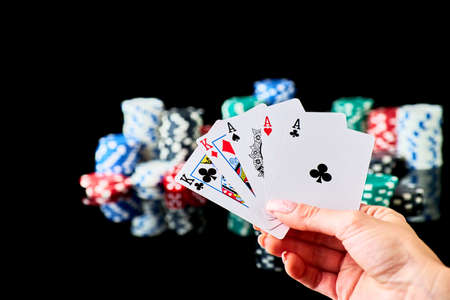 Casino chips, playing cards and dices on dark reflective background