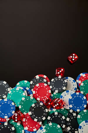 Frame made of Casino chips and dices on dark reflective background with copy space