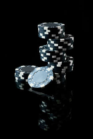 Stack of Casino gambling chips isolated on black reflective backgroundの写真素材
