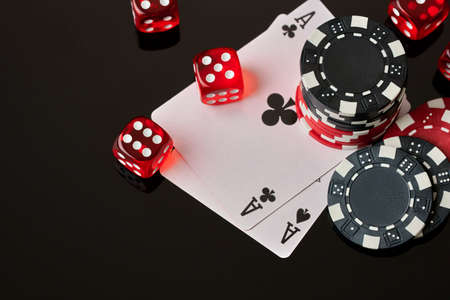 Casino chips, playing cards and dices on dark reflective background