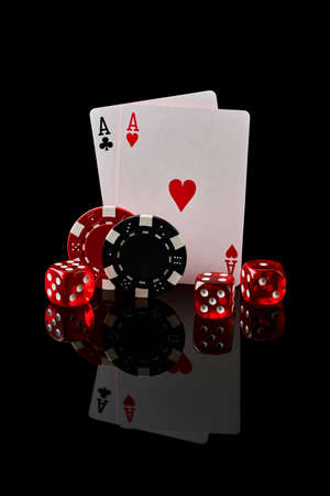 Casino chips, playing cards and dices on dark reflective backgroundの写真素材