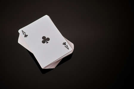 Full deck of playing cards with ace on top on dark reflective background