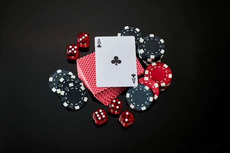 Casino chips, playing cards and dices on dark reflective backgroundの写真素材