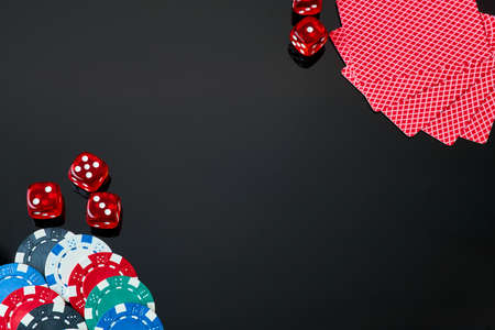 Casino chips, playing cards and dices on dark reflective backgroundの写真素材