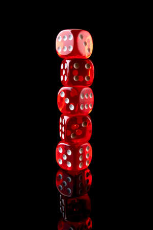 Red casino dice isolated over black reflective backgroundの写真素材
