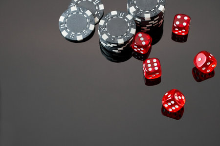 Red casino dice and chips isolated over black reflective backgroundの写真素材