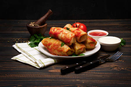 Portion of stuffed cabbage rolls on wooden table