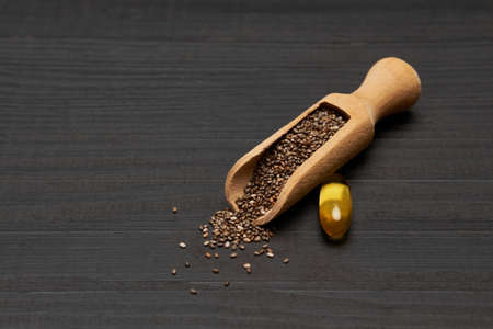 Organic natural chia seeds and wooden scoop close-up on wooden background or tableの写真素材