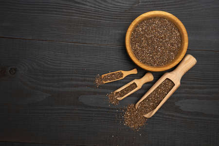 Organic natural chia seeds and wooden scoop close-up on wooden background or tableの写真素材