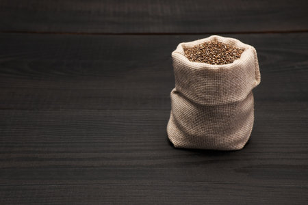 pouch full of Organic natural chia seeds on dark wooden background or tableの写真素材