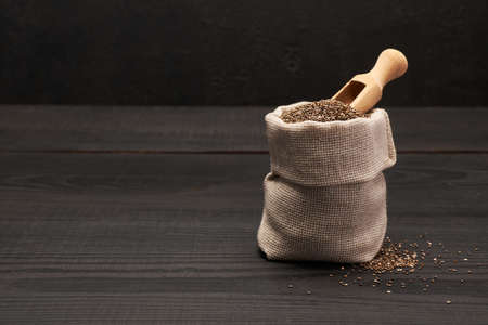 pouch full of Organic natural chia seeds on dark wooden background or tableの写真素材