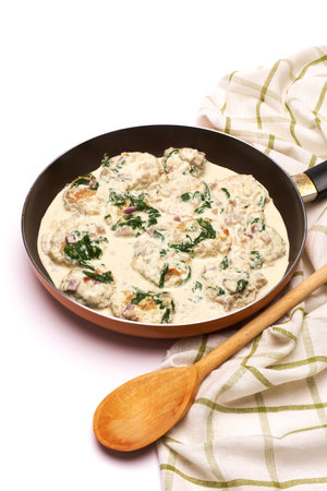Delicious small meatballs with spinach in a creamy sauce in the frying panの写真素材