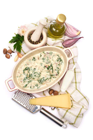 Delicious meatballs with spinach in a creamy sauce in baking dish on white backgroundの写真素材