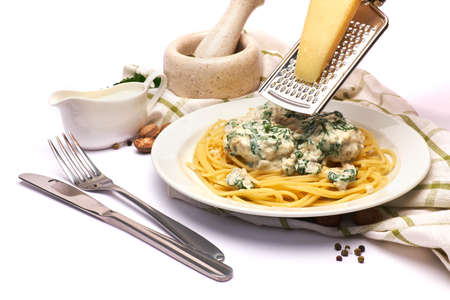 Portion of delicious meatballs with spinach in a creamy sauce and pastaの写真素材