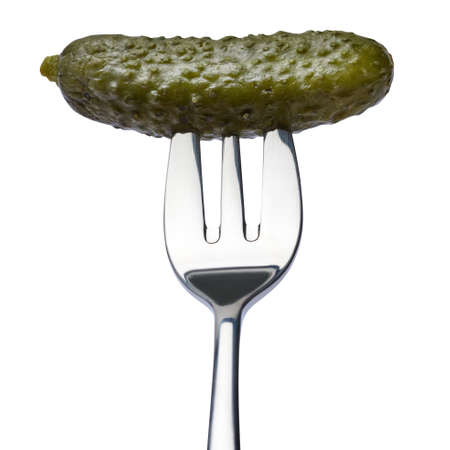 Tasty canned Whole green cornichon on a fork isolated on a white backgroundの写真素材